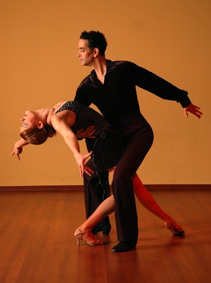 Professional ballroom dance class in Manchester city centre studio with couples practicing elegant waltz and foxtrot on spacious dance floor