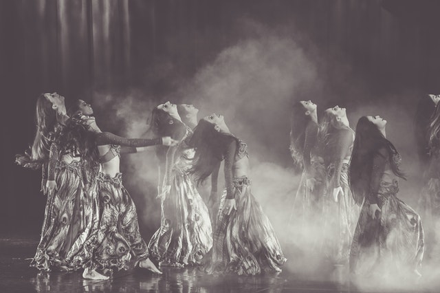 Professional belly dance class in Manchester city centre studio with women practicing expressive Middle Eastern dance movements and isolations